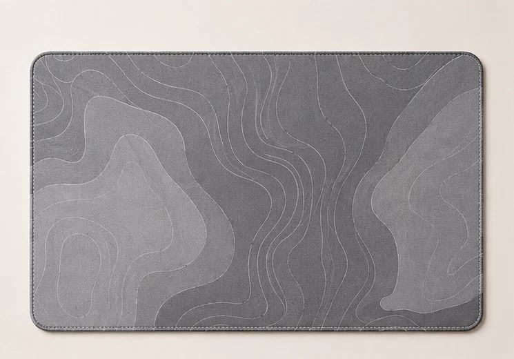 Grey desk mat with abstract contour flow and contrast stitching
