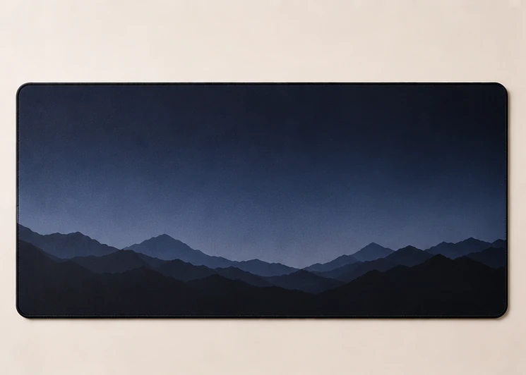 Extended desk mat with layered mountain ridge silhouettes at dusk