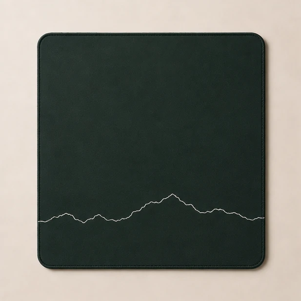 Full-desk mat with a white panoramic mountain ridge line on deep green
