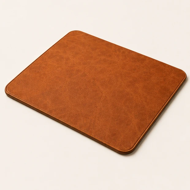 Three-quarter view of the Tan Leather Mouse Mat showing its edge profile