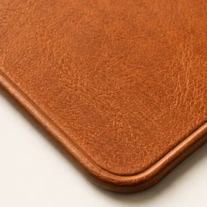 Close-up of the leather grain and embossed edge of the Tan Leather Mouse Mat